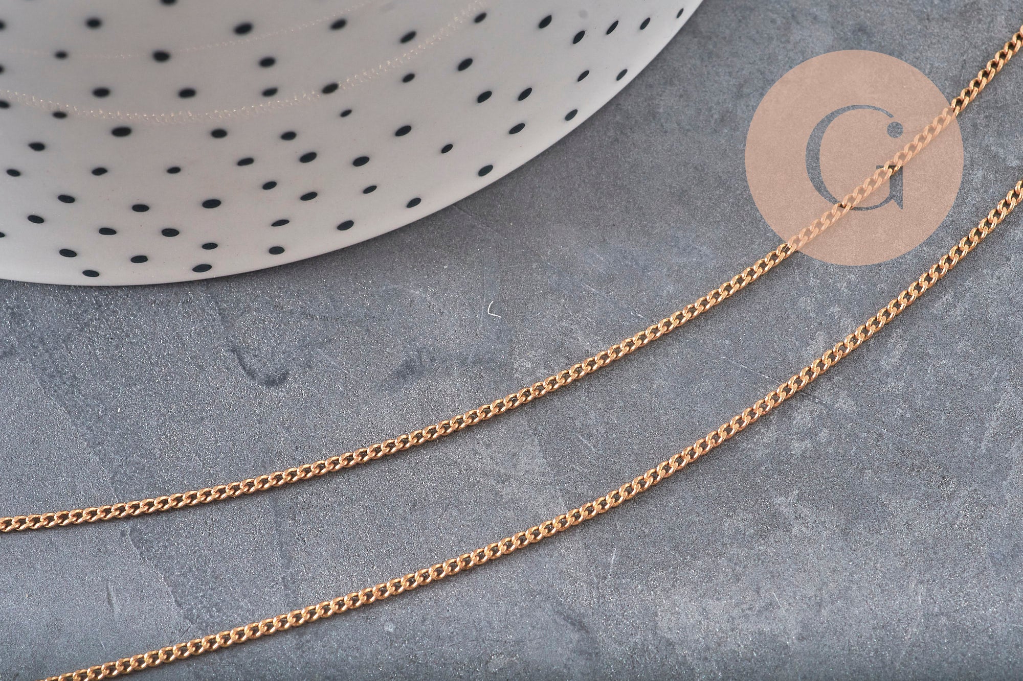 Chaîne plate en laiton brut de 1,5 mm pour bijoux DIY, présentée sur un fond gris texturé.