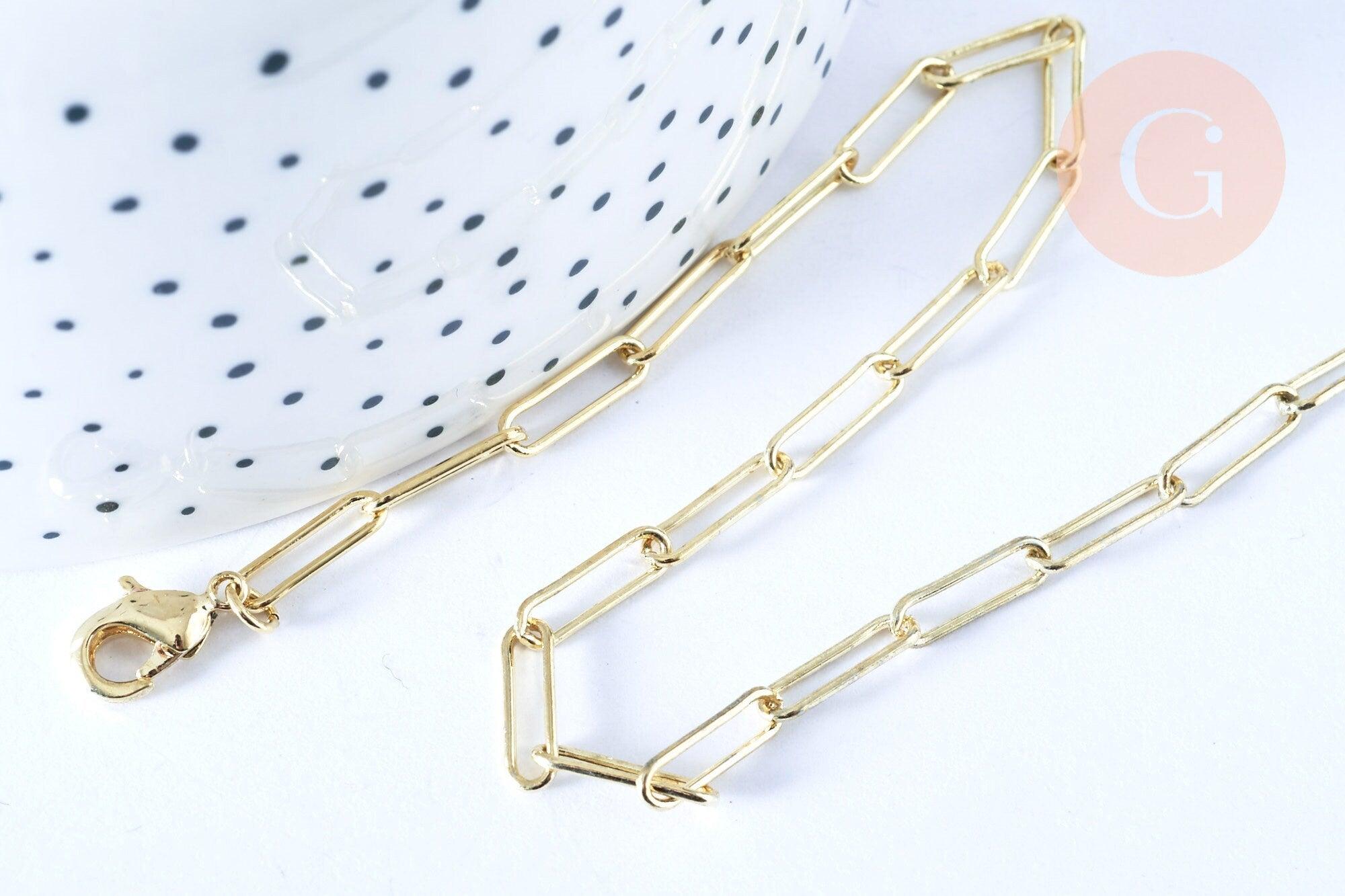 Gold paperclip chain necklace with lobster-claw clasp on white surface; features 12x3.5mm rectangular links, 46.5cm length. Collier Chaine laiton doré clair maille rectangle.
