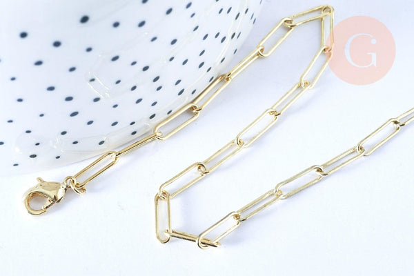Gold paperclip chain necklace with lobster-claw clasp on white surface; features 12x3.5mm rectangular links, 46.5cm length. Collier Chaine laiton doré clair maille rectangle.