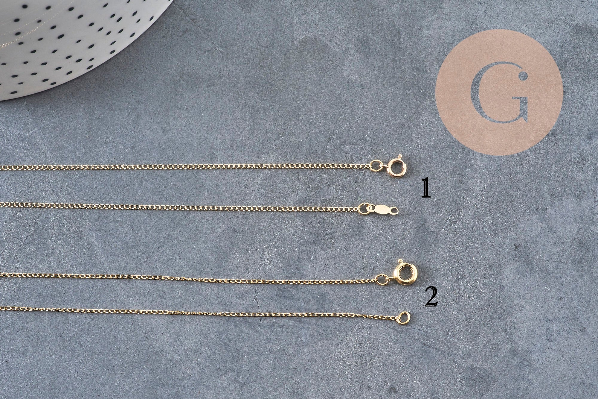 Collier chaîne fine dorée gold-filled 45.7cm avec fermoir, vue de dessus sur fond gris.