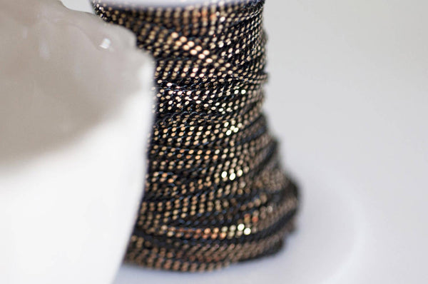 EP-Chaine fine maille plate noire reflets dorés 1.5mm, X 5 mètres G0554