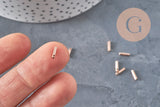 Embouts de cordon cylindriques en acier inoxydable or rose 7x1.6mm pour bijoux DIY, tenus sur le bout d'un doigt.