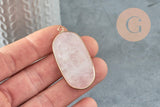 Close-up of fingertips holding a rose quartz pendant in a thin gold bezel, perfect for chic bohemian jewelry. Pendentif hexagone quartz rose naturel 49mm, x1 (G2506).