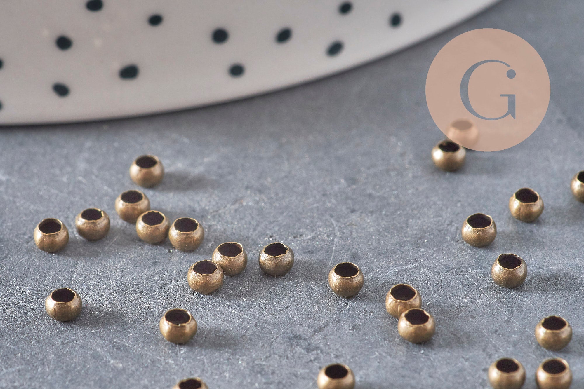 Perles à écraser rondelles en laiton couleur bronze 3x2mm, dispersées sur une surface grise.